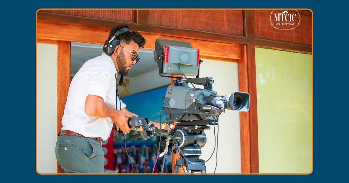 A man operates a camera during horse racing at the Champ de Mars racecourse in Port Louis
